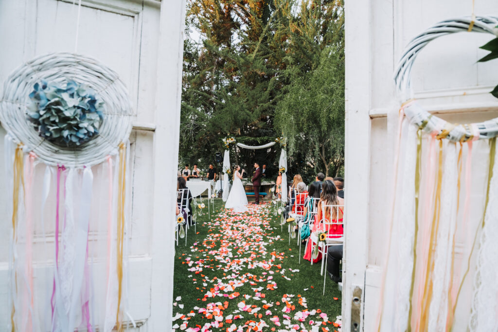 ceremonia de matrimonio con entrada decorada y pétalos de flores en alto de pirque