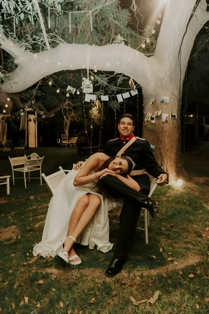 pareja disfrutando de un momento de relajación y felicidad bajo un árbol iluminado en alto de pirque