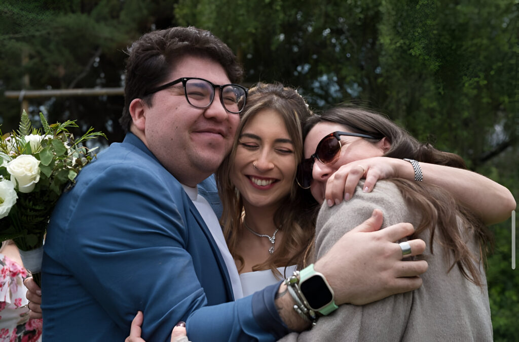 novios celebrando un momento especial con un abrazo en compañía de sus seres queridos en alto de pirque