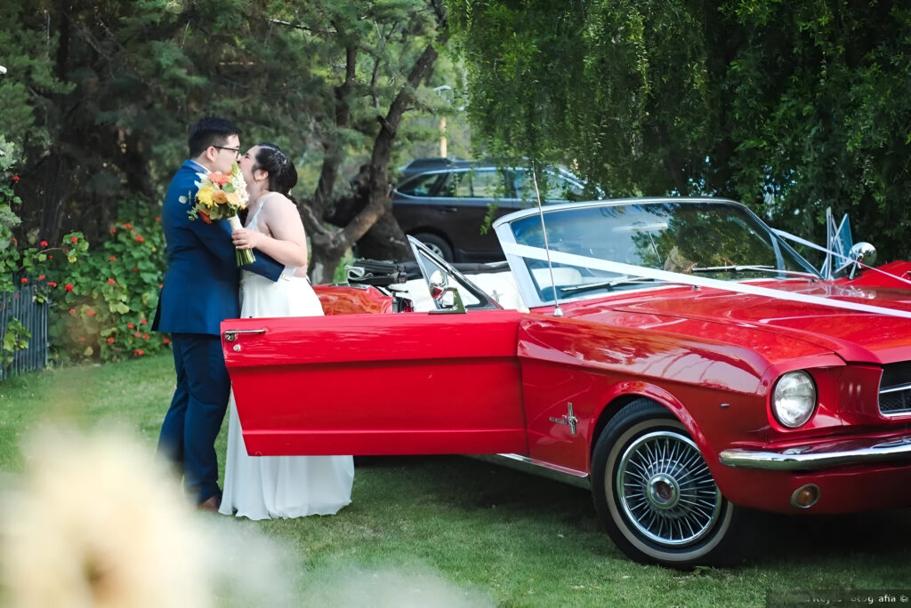 novios en auto clásico disfrutando de su boda en alto de pirque