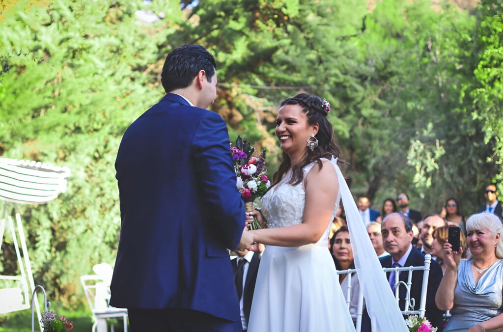 pareja de novios intercambiando votos en una ceremonia en alto de pirque